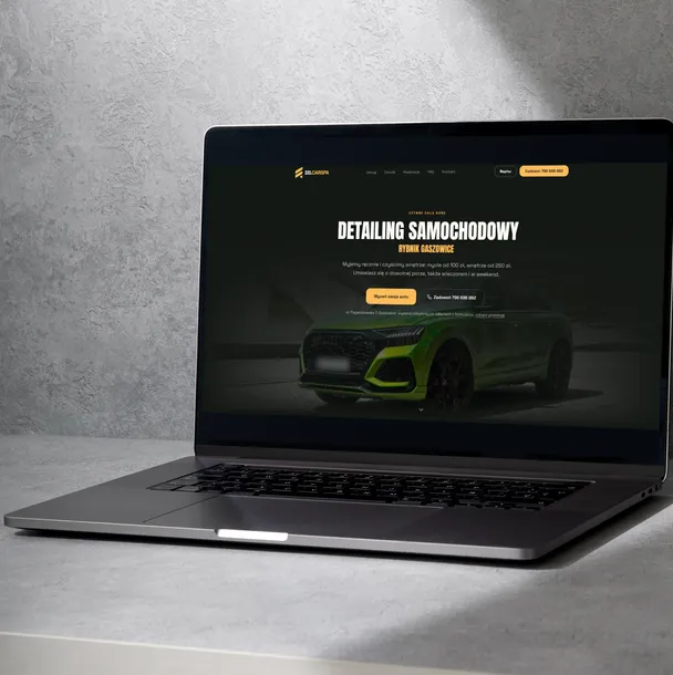 Laptop na szarym betonie ze stroną ddcarspa.pl: detailing samochodowy, zielone auto, żółte akcenty